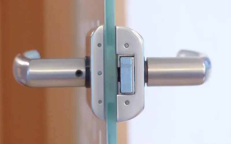 close-up of a metal security lock mechanism on a glass door