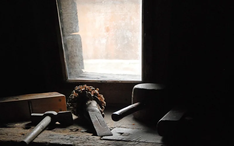 Wood chisel and wooden mallet resting on a workbench near a window Wood chisel and wooden mallet resting on a workbench near a window