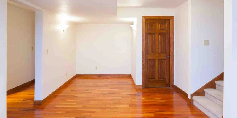 A hardwood floor and matching solid-wood interior door in a finished room