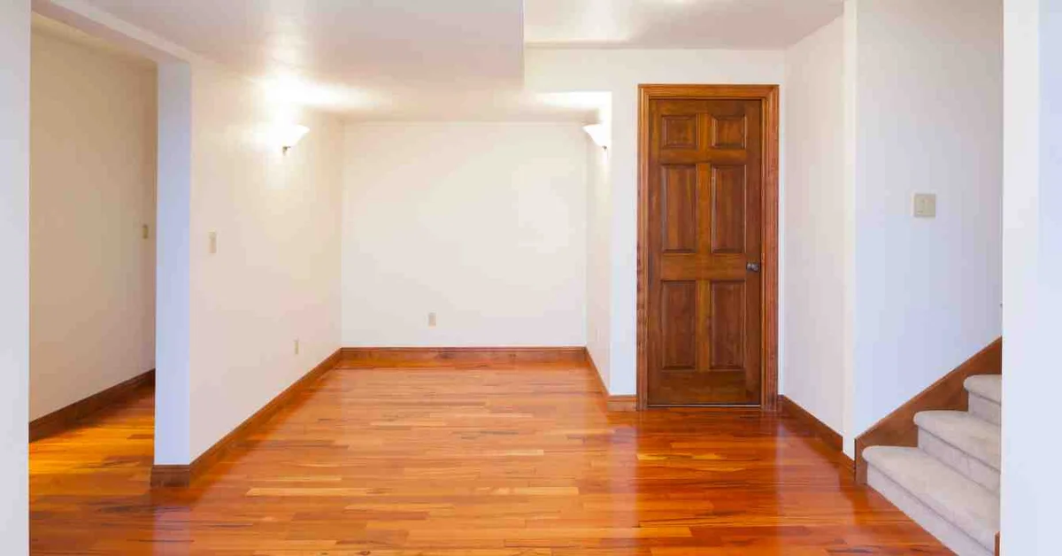 A hardwood floor and matching solid-wood interior door in a finished room