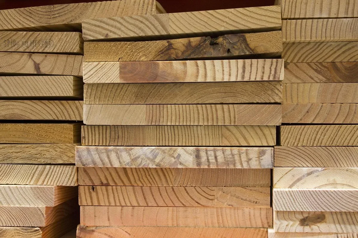 Stacked hardwood lumber boards at a lumberyard