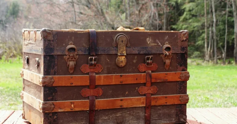 Antique wooden steamer trunk with metal straps and latches on a deck
