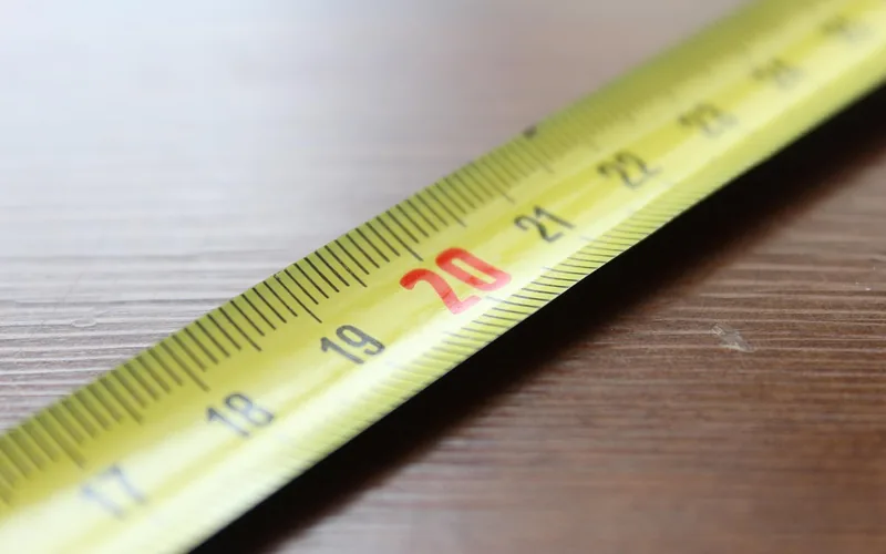 Tape measure closeup used to check garage cabinet width, height, and depth before buying Tape measure closeup used to check garage cabinet width, height, and depth before buying
