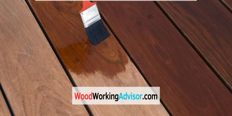 Applying stain to a deck board with a paintbrush