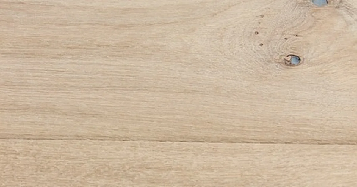 Close-up of light oak flooring planks with a warm beige tone and visible wood grain