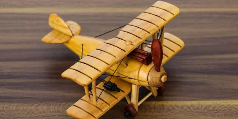 Hand-carved wooden biplane model showing the wing rib detailing typical of mahogany aircraft replicas