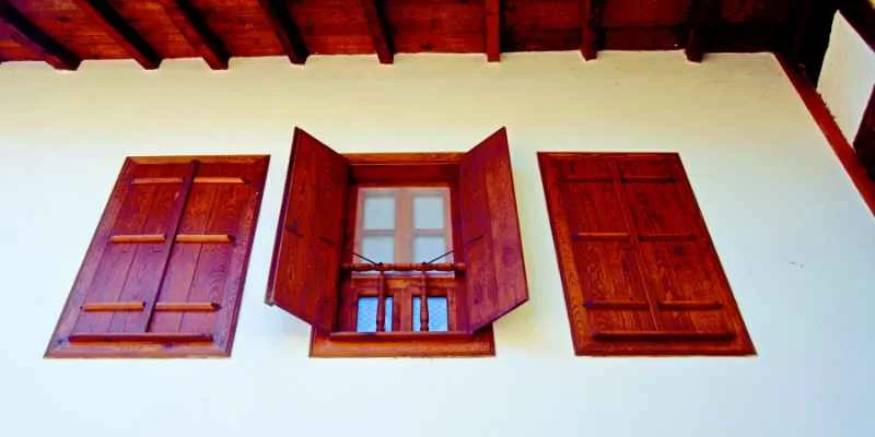 Mahogany wood window with shutters on a home exterior