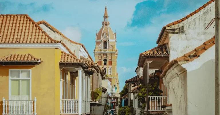 Colorful Spanish colonial balconies and cathedral tower in a historic Cartagena street