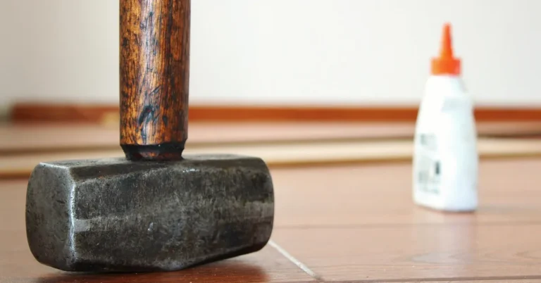 Rubber mallet resting beside a glue bottle on a wood board, ready to tap a clamp-free joint tight
