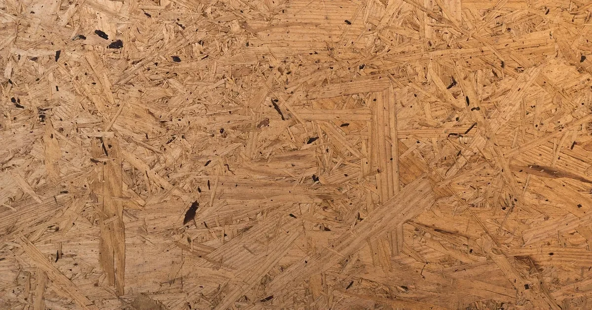 Close-up of an oriented strand board surface showing the layered wood strands used in manufactured wood