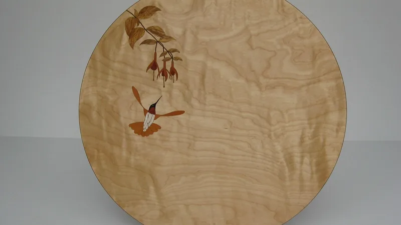Marquetry panel with an inlaid hummingbird and flowers on figured wood