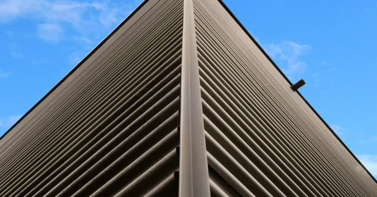 Metal corner trim strip finishing the edge of a corrugated metal building facade