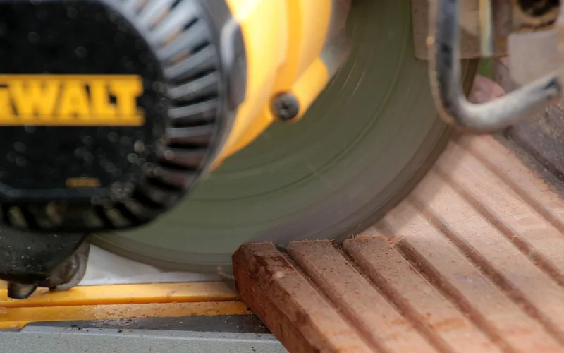Blade guard and rotating blade on a chop-style miter saw showing the safety shield in position
