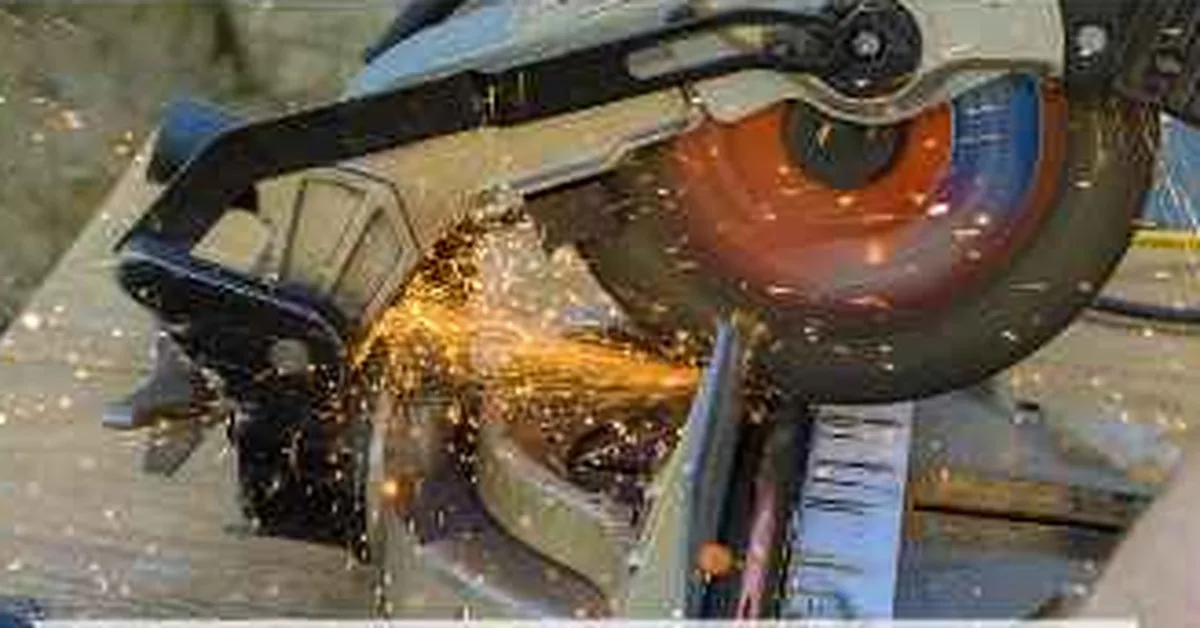 Miter saw with laser guide cutting through a board, sparks flying off the blade