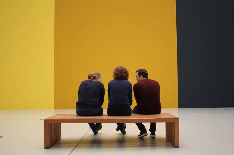 Museum visitors viewing a furniture exhibit, representing the museum collections that hold Sam Maloof's work