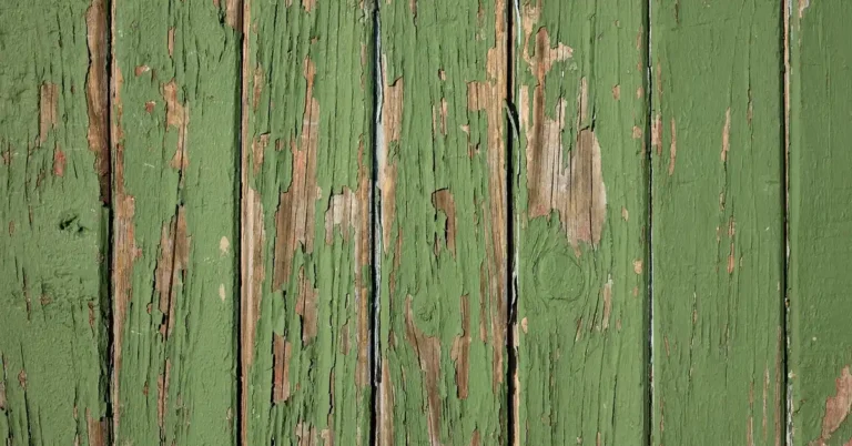 Old green paint peeling off a wood board before stripping and neutralizing