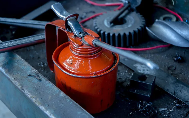 oil can and hand tools on a workbench for lubricating cast iron machinery
