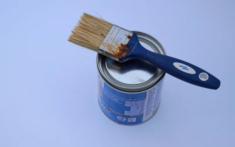 Can of primer with a paint brush laid across the top, ready for cabinet prep work Can of primer with a paint brush laid across the top, ready for cabinet prep work