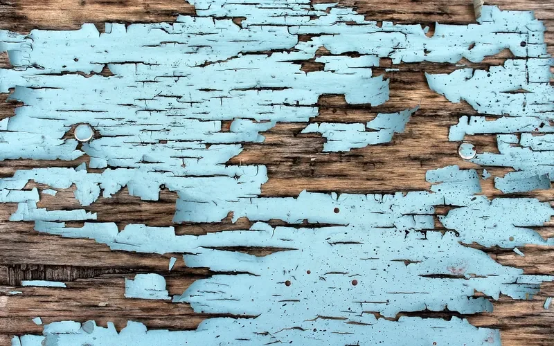 Peeling paint and cracked finish on an old wooden board Peeling paint and cracked finish on an old wooden board