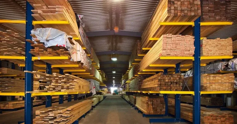 Stacked plywood and lumber sheets on warehouse racking at a supply yard
