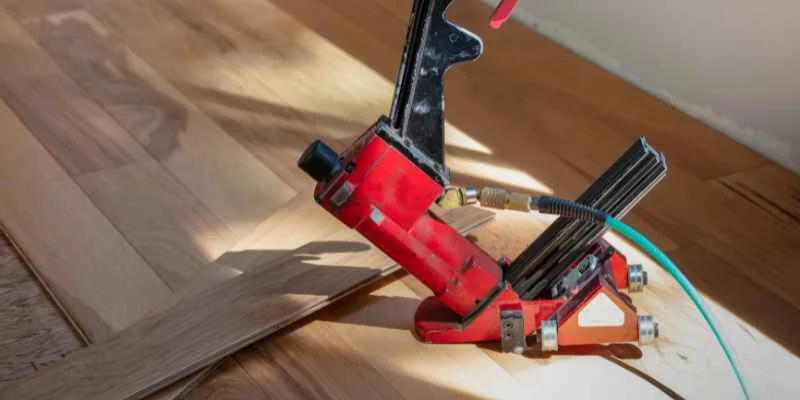 Pneumatic flooring nailer driving cleats into hardwood plank flooring