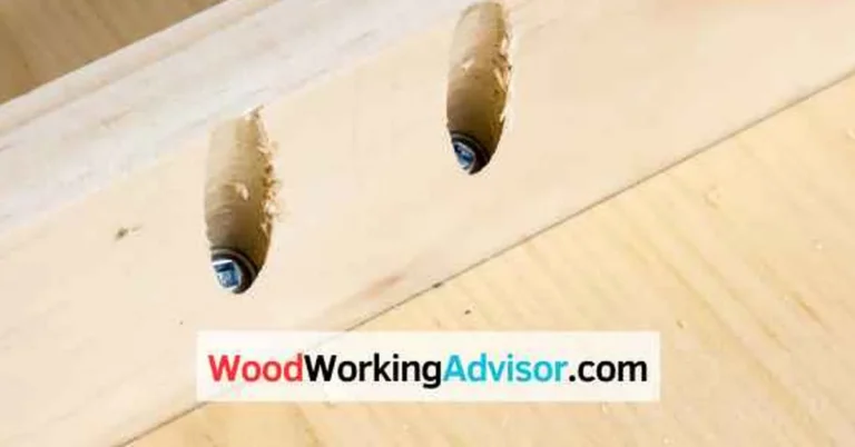 Two pocket holes drilled at an angle in a pine board with a Kreg screw seated in one