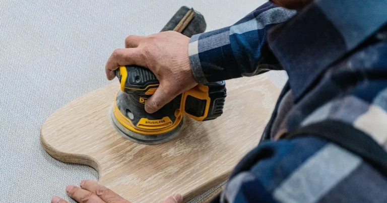 Random orbit sander sanding an oak board with hook and loop sandpaper
