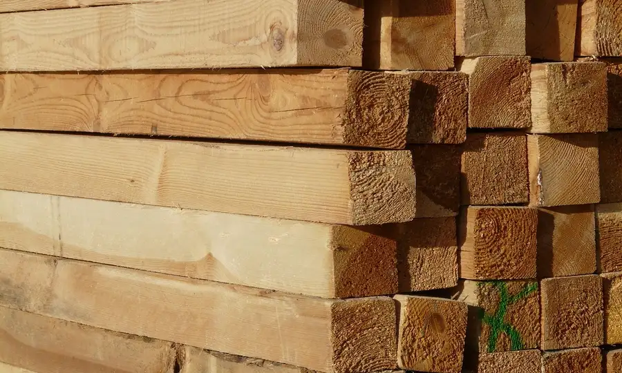 Stack of thick hardwood boards ready to be resawn on a bandsaw