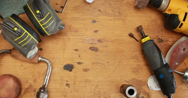 Assorted corded power tools and hearing protection on a wooden workbench