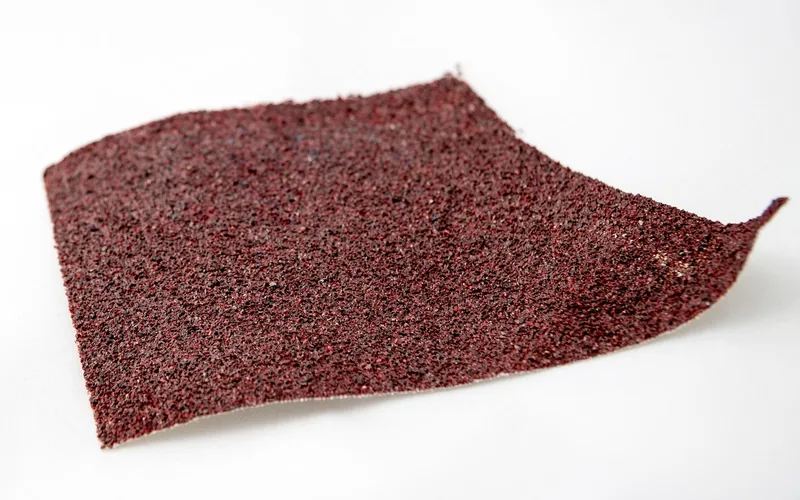 close-up of red sandpaper grit texture used for sanding latex paint between coats close-up of red sandpaper grit texture used for sanding latex paint between coats