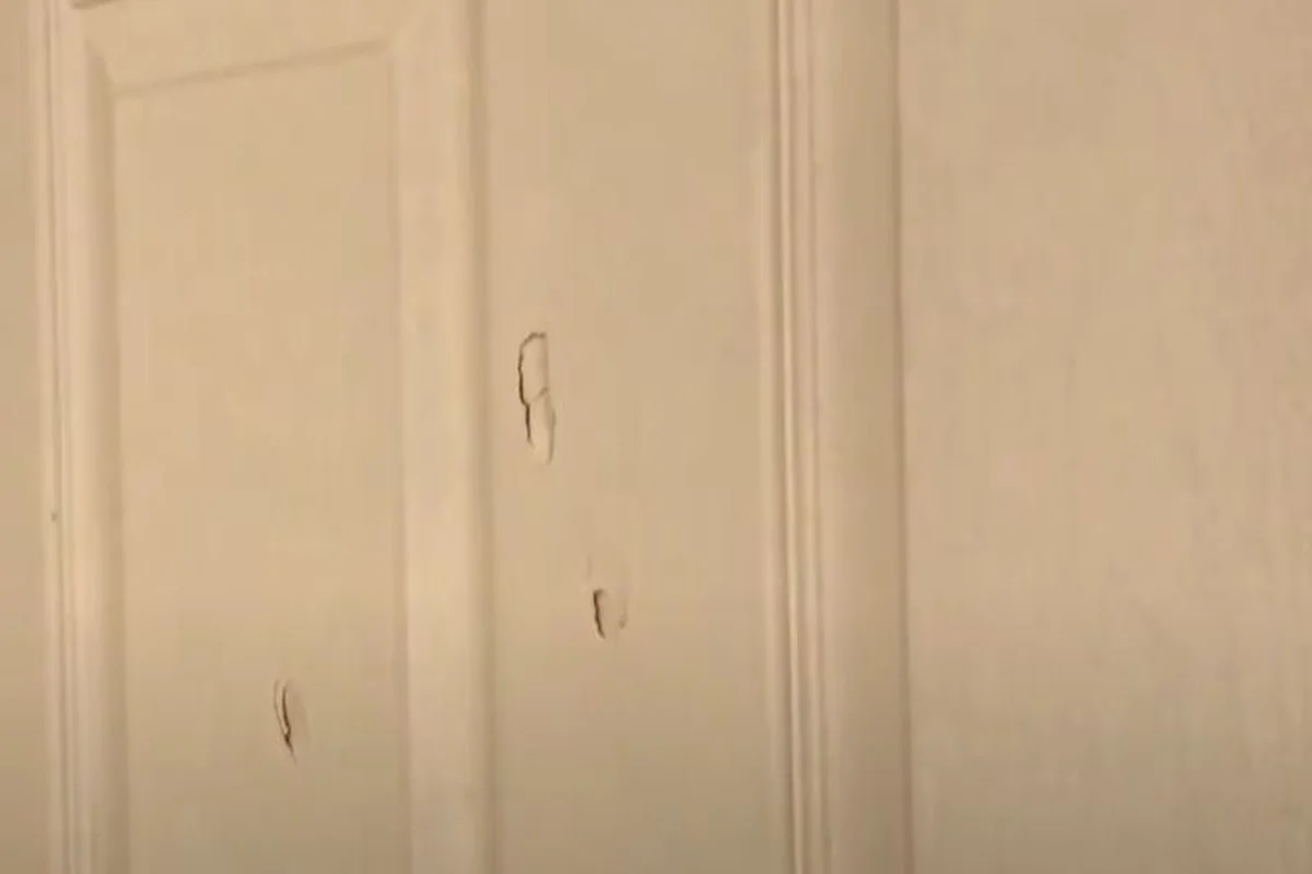 Several small nail holes in a white painted door