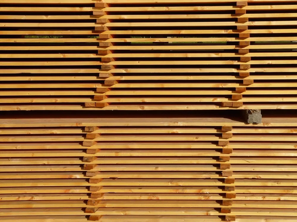 Stacked dimensional lumber boards separated by spacer sticks in a lumber yard