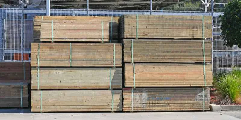 Stacked pressure treated lumber boards at a lumber yard