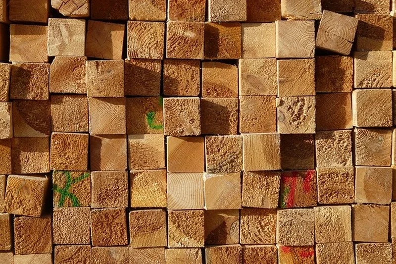 Stacked squared lumber ends showing growth rings and mill grading marks