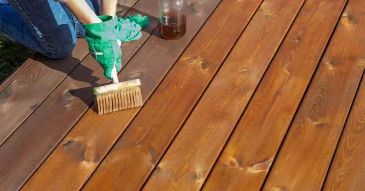 Applying wood stain to pressure treated deck boards with a brush