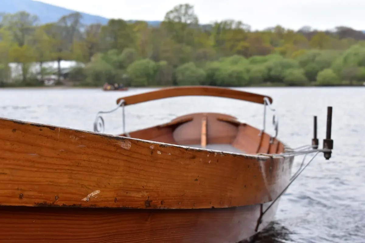 Varnished plywood-look wooden rowboat moored on a calm lake