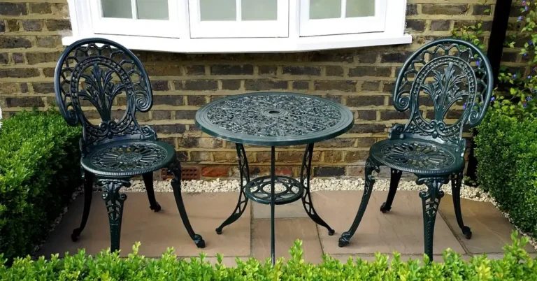 stone paving tile patio with bistro table and chairs against a brick house wall