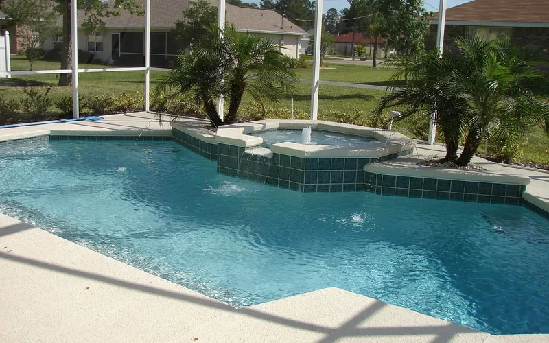 tiled stone pool deck coping and surrounding patio in a backyard setting