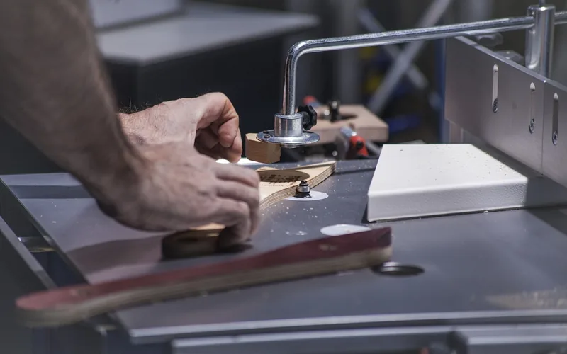 Woodworker adjusting a workpiece against a table saw fence and guide