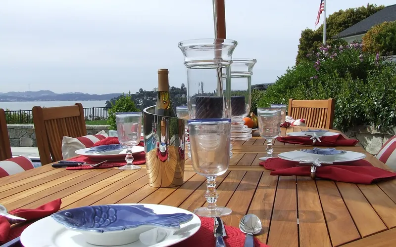 Teak outdoor dining table set for a meal Teak outdoor dining table set for a meal