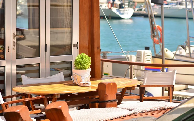 teak table and deck flooring on a yacht moored in a marina