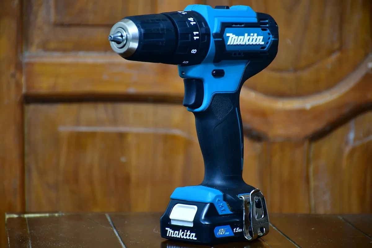 A Makita cordless drill on a wood workbench A Makita cordless drill on a wood workbench