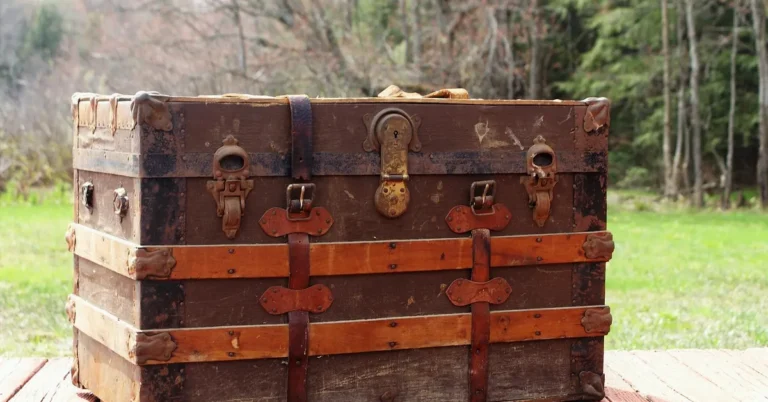 Vintage wood storage trunk with leather straps sitting outdoors