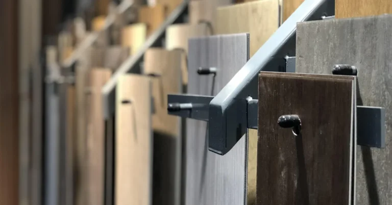 Rows of laminate and vinyl plank flooring samples displayed on a showroom rack