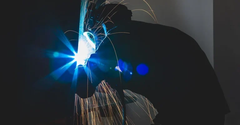 Welding sparks flying near a workshop table showing the fire risk to bare wood