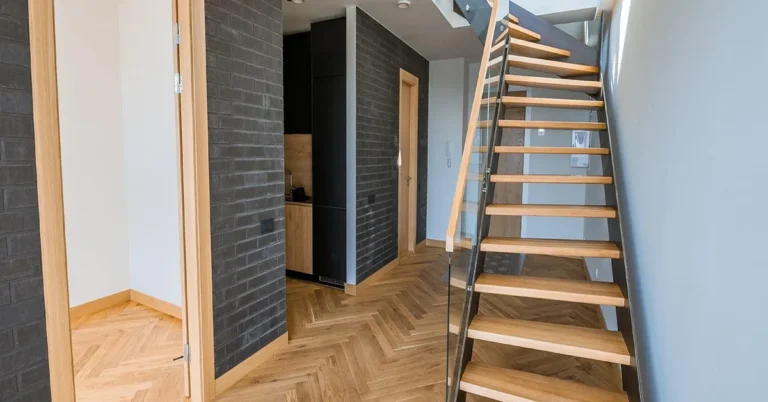 White ash wood flooring installed in a herringbone pattern in a modern hallway