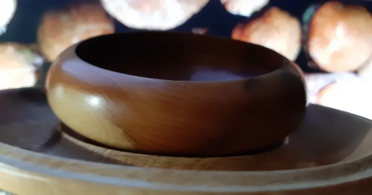 Freshly turned wood bowl on a lathe, showing the even wall thickness that helps prevent cracking