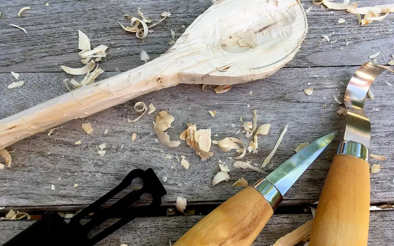 wood carving knife and basic hand tools laid out for a whittling project