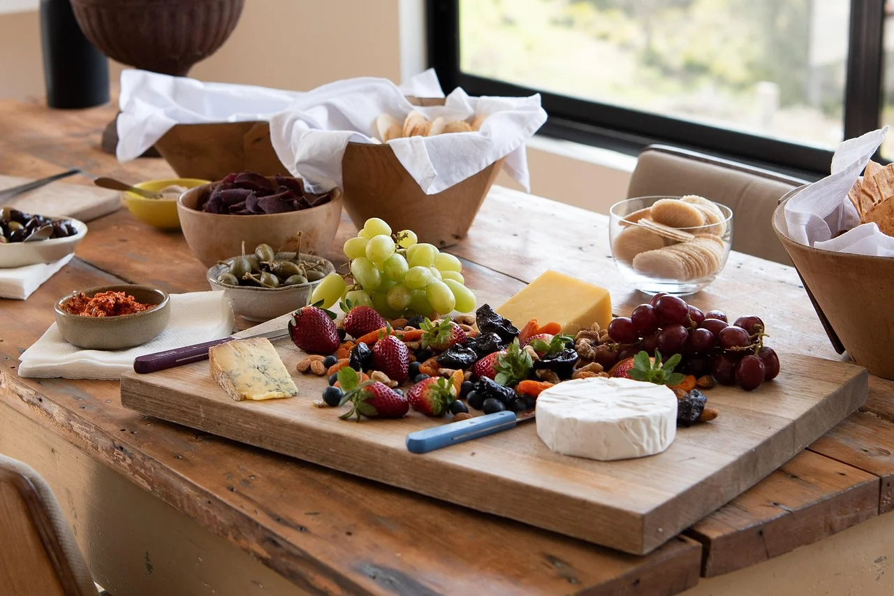 Finished wooden cheese board served with cheese, fruit, and crackers