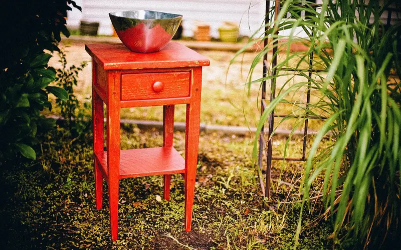 Small wood accent table with visible paint wear and chips from years of use Small wood accent table with visible paint wear and chips from years of use